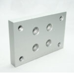Rectangular aluminum mounting plate with multiple circular holes for fastening.