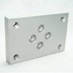 Rectangular aluminum mounting plate with five central holes and four corner threaded holes.
