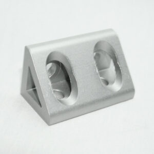 Angled silver metal block with two large circular holes on its face, likely a mounting bracket or connector piece.