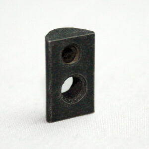 Small black rectangular block with two circular holes (one large, one small) on a white surface.