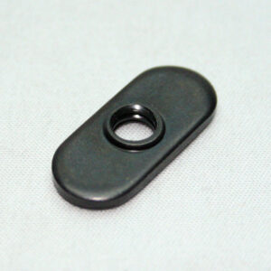 Black oval plastic mounting plate with a central threaded hole on a light fabric background.