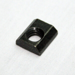 Black square nut with a threaded hole on a white fabric background.