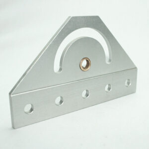 Silver triangular metal bracket with a curved slot and a central bronze bushing, resting on a flat base with five evenly spaced holes along the bottom edge.