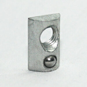 Small steel block with a large through hole and a metal ball at the bottom, standing on a light surface.