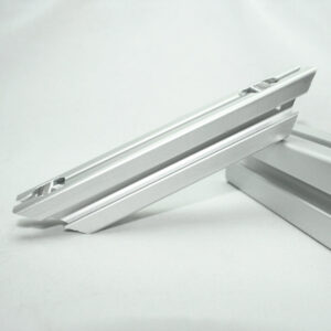 Two white metal rails with small silver clips resting on a white surface.