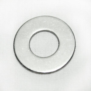 Close-up of a silver metal washer on white fabric surface.