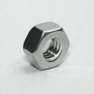 Metal hex nut resting on a white surface, with visible internal threads.