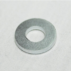 Metal washer on a white textured background, circular ring with a central hole.