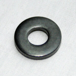 Flat, ring-shaped metal washer on a light fabric background