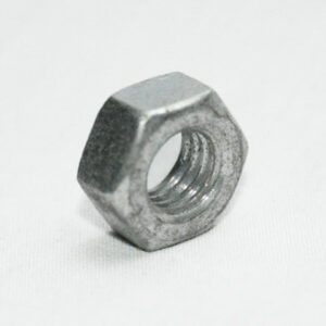 Metal hex nut resting on a white surface, showing interior threads.