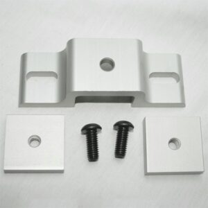 Silver metal mounting bracket with two square spacers and two black screws laid out on a pale surface