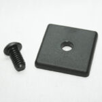 Black screw and square plastic spacer with a central hole on a white surface—likely a furniture fastener set component