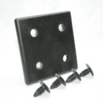 Black mounting plate with four holes and four black drive screws laid in front of it, hardware for installation.
