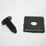 Black plastic screw and a square black snap cap with a central hole on a white background