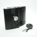 Compact black lockable container with a silver keyhole; two metal keys lie next to it on a white background.