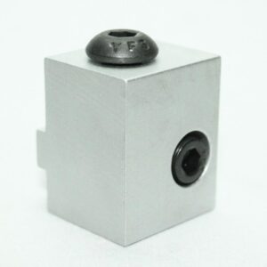 Gray rectangular block with a black recessed hole on the side and a small notch on the left edge; a round black stud sits on top.