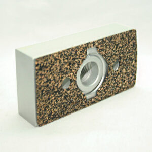 15AC8707_2__editedjpg | Faztek Industrial Solutions Rectangular block with cork-textured front and a central metal threaded insert surrounded by two small holes (mounting plate).