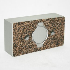 15AC8709_2__editedjpg | Faztek Industrial Solutions Grey circular watch face embedded in a speckled cork slab mounted on a pale gray rectangular block.