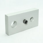 Silver rectangular metal block with three holes: two large end holes and a central threaded bore with insert.