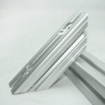 Two silver aluminum extrusion rails with grooved channels leaning against each other on a white background.