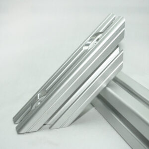 Two silver aluminum extrusion rails with grooved channels leaning against each other on a white background.