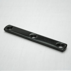 Black metal spacer bar with three threaded holes on a light background, laid flat and angled slightly.