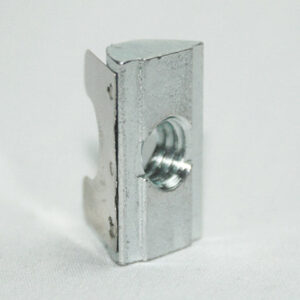 Small metal bracket with a central threaded hole, standing on a white surface, featuring a curved side tab