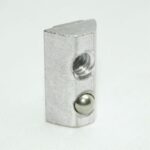 Small silver metal rectangular block with a threaded hole and a rounded ball on its side, on a white surface.