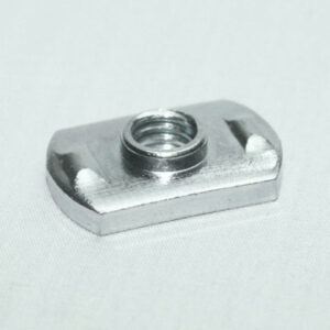 Metal captive nut on a small rectangular block with a central threaded hole and curved side recesses on a light surface.