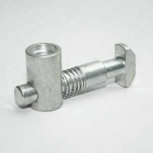 Small silver metal bolt with a threaded midsection and a square head on the right, lying on a white surface.
