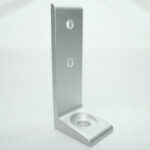 Silver metal L-bracket with two holes on the vertical leg and a round mounting hole in the base, photographed on a light background.