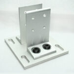 Aluminum mounting bracket with a base plate featuring two slotted holes and a vertical support plate with four punched holes, designed for surface mounting.