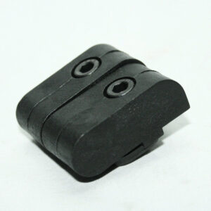 Close-up of a small black plastic device with two circular holes on a white background.