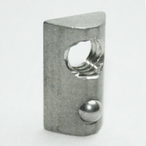Small gray metal component with a circular through-hole and a silver ball detent on the side, photographed up close.