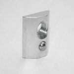 Metal curved rectangular block with a large threaded hole on the face and a small ball detent on the side.
