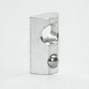 Metal detent ball plunger with a threaded hole, standing on a white surface.