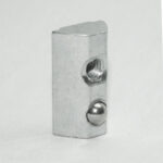 Metal rectangular block featuring a threaded hole and a protruding steel ball detent on its right face (ball plunger component).