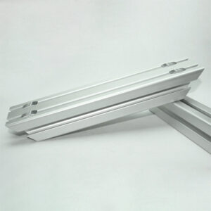 Two parallel silver aluminum T-slot extrusion rails with slotted features resting on a light background.