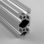 Close-up of gray aluminum extrusion profiles with T-slot channels used for modular framing and assembly.