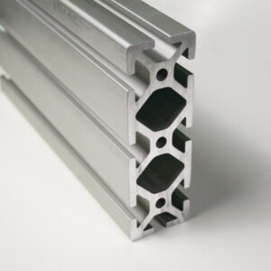 Close-up of a silver aluminum extrusion profile with multiple T-slot channels for modular framing systems.