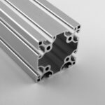 Close-up of a silver aluminum extrusion profile with multiple T-slot channels for modular framing systems.
