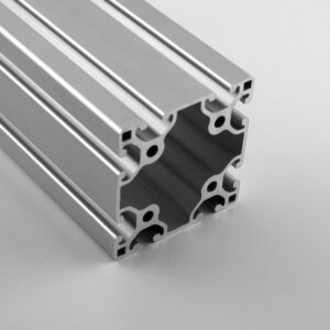 Close-up of a silver aluminum extrusion profile with multiple T-slot channels for modular framing systems.