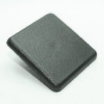 Black rectangular block with rounded corners and a matte finish, photographed at an angle.
