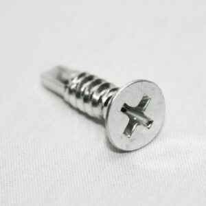 Close-up of a silver Phillips-head screw on a pale surface at an angle.