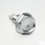 Close-up of a shiny metal hex bolt head on a white background.